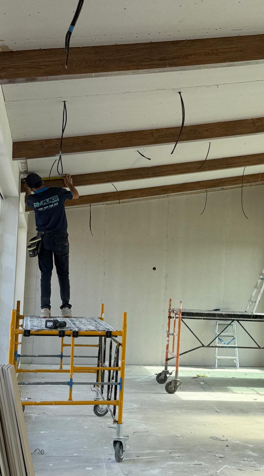 Técnico da RM PLACO a instalar teto em pladur com vigas decorativas em imitação de madeira durante obra de remodelação